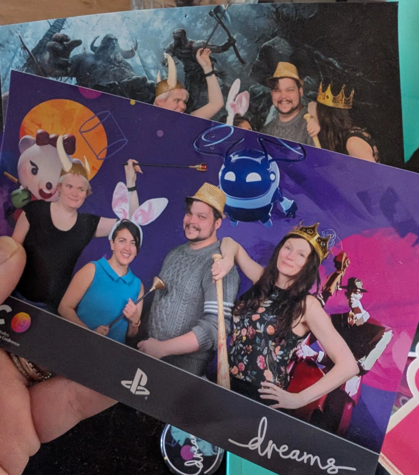 Photobooth prints from GTC 19, the SIE Worldwide Studios Game Technology Conference. Four people in party props pose in front of a Dreams backdrop, with a second print behind using a God of War backdrop